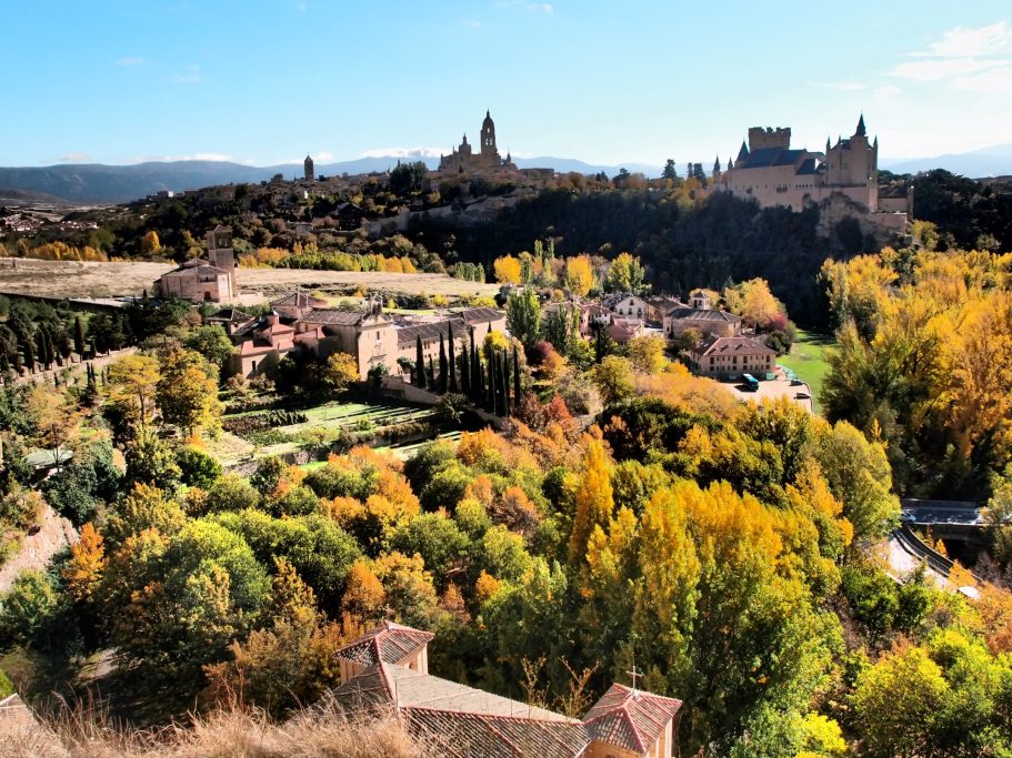 Vista panorámica de una ciudad histórica rodeada de árboles otoñales.
