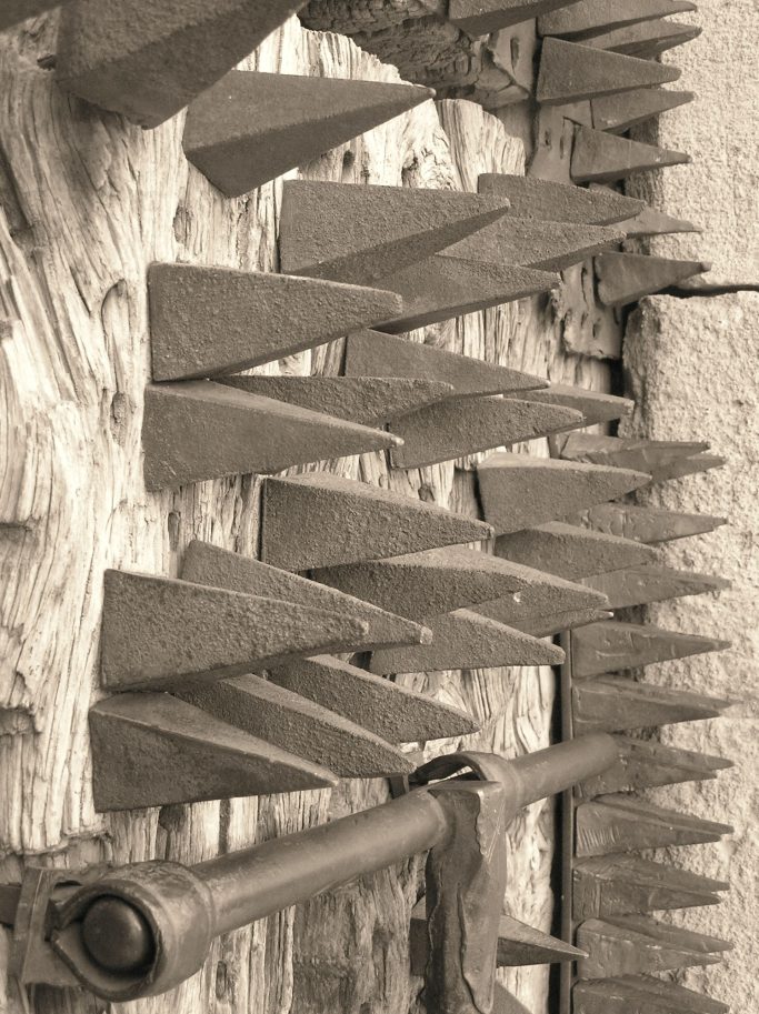 Punciones metálicas en forma de triángulo sobre una superficie de madera envejecida.